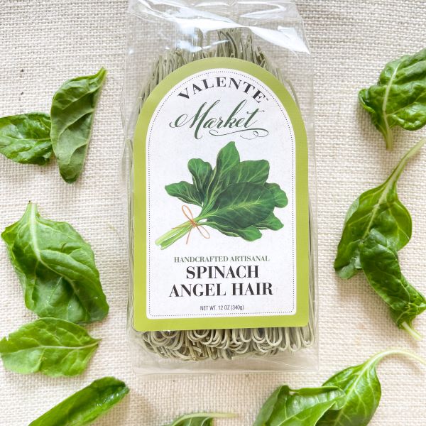 Spinach angel hair pasta with fresh spinach and a pale green border on the label on a clear bag
