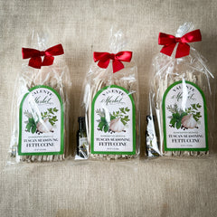 Three Gift Bags of Tuscan Seasoning Fettuccine tied up with a bow and a mini bottle of olive oil