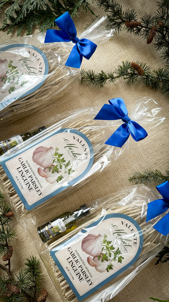 Three Gift Bags of Garlic Parsley Linguine tied with a bow and a mini bottle of olive oil