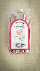 Packaged pasta with a decorative label on a textured beige background