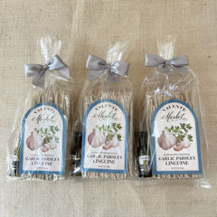 Three Gift Bags of Garlic Parsley Linguine tied with a bow and a mini bottle of olive oil