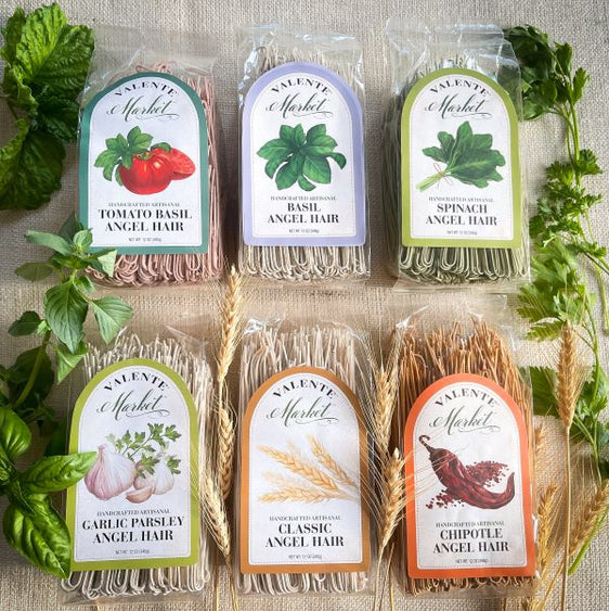 Brightly labeled angel hair pasta assortment including, six 12 oz packages. One Tomato Basil Angel Hair, one Basil Angel Hair, one Spinach Angel Hair, one Garlic Parsley Angel Hair, one Chipotle Angel Hair.
