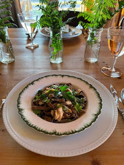 Mushroom fettuccine served in a white bowl with green rim