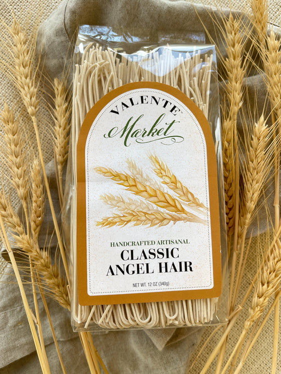Classic angel hair pasta in a clear bag with a wheat stalk and natural colored borderlabel. Wheat stalks surround the bag
