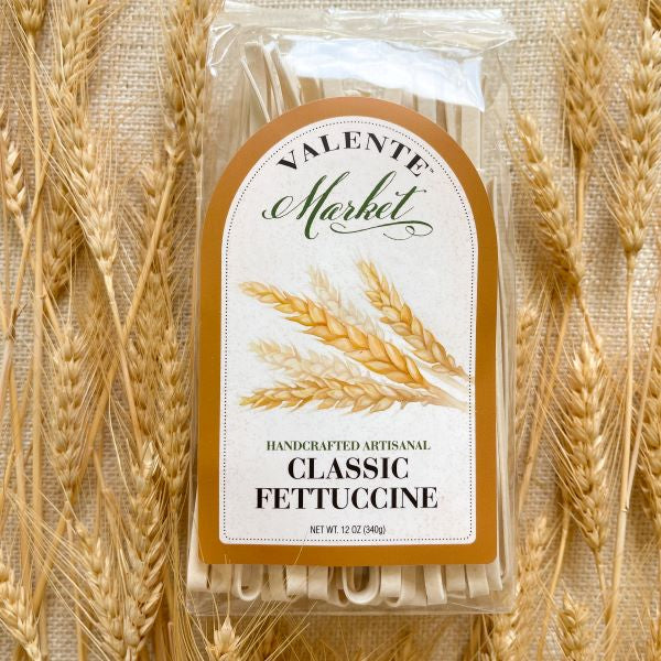 Classic fettuccine pasta in a clear bag with a wheat stalk and natural border on the label. Wheat stalks surround the bag