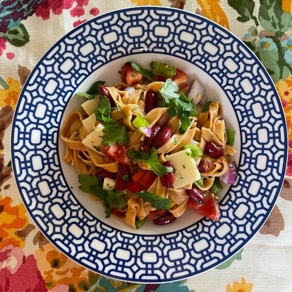 Red pepper fettuccine pasta salad in blue and white Caskata bowl